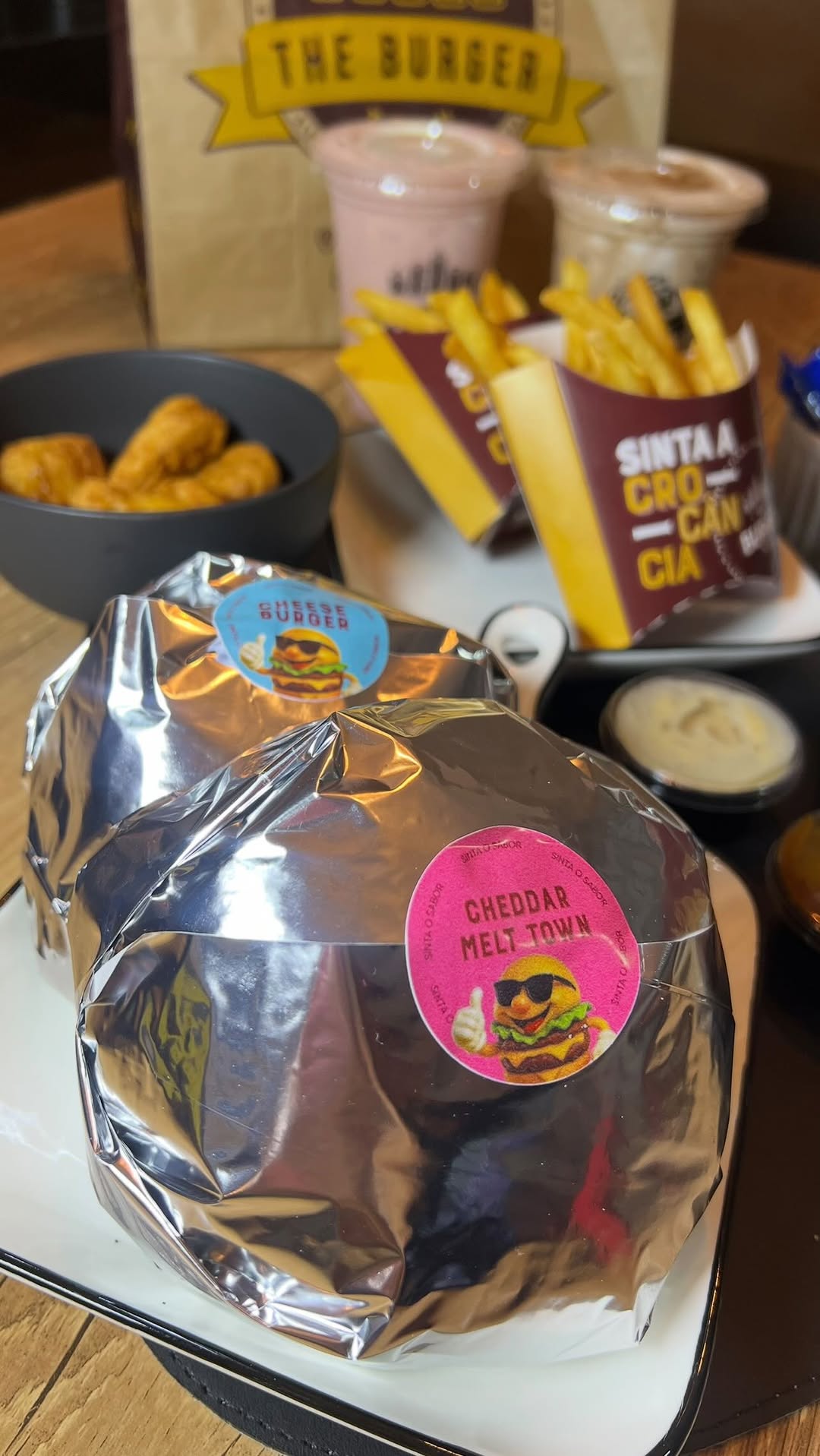 Pedido completo da The Burger Town com burgers, batata e bebidas